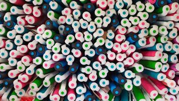 Abstract background of multicolored caps of plastic pens. A set of several liners, markers and colored markers of different colors, top view photo