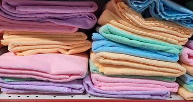 Colorful terry towels are on the shelf of the store. photo