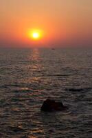 Sunset on the background of the cliffs of Goa photo