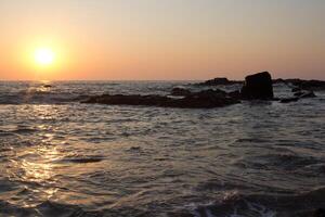 Sunset on the background of the cliffs of Goa photo