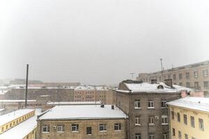 Snow blankets the rooftops of Saint Petersburg, capturing a somber winter cityscape amidst a heavy snowfall photo