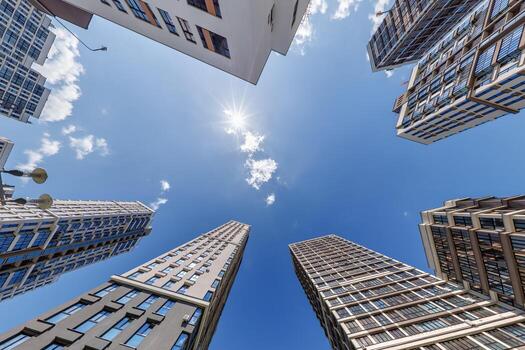 ver desde abajo dentro azul cielo con nubes de grande moderno rascacielos residencial complejo foto