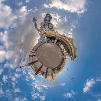 tallest hindu shiva statue in india on mountain near ocean on little planet in blue sky with evening clouds, transformation of spherical 360 panorama. Spherical abstract view with curvature of space. photo