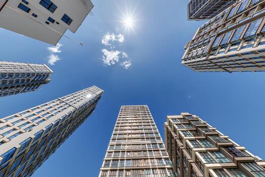 ver desde abajo dentro azul cielo con nubes de grande moderno rascacielos residencial complejo foto