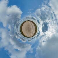 simple tiny planet without buildings in blue sky with beautiful clouds. Transformation of spherical panorama 360 degrees. Spherical abstract aerial view. Curvature of space. photo