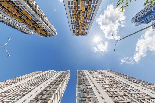 ver desde abajo dentro azul cielo con nubes de grande moderno rascacielos residencial complejo foto