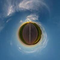 simple tiny planet without buildings in blue sky with beautiful clouds. Transformation of spherical panorama 360 degrees. Spherical abstract aerial view. Curvature of space. photo