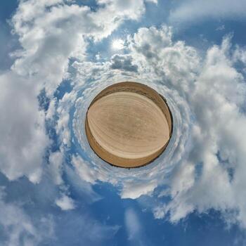 simple tiny planet without buildings in blue sky with beautiful clouds. Transformation of spherical panorama 360 degrees. Spherical abstract aerial view. Curvature of space. photo