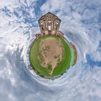 little planet and spherical aerial 360 panorama view on street ancient medieval castle with church and historic buildings with columns photo