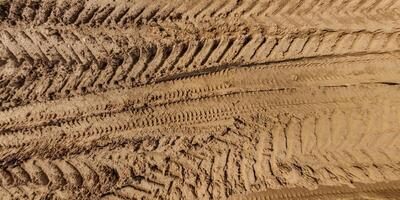 view from above on texture of wet muddy road with tractor tire tracks in countryside photo