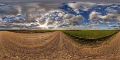 360 hdri panorama view on no traffic gravel road among fields in spring day with beautiful clouds in equirectangular full seamless spherical projection, ready for VR AR photo