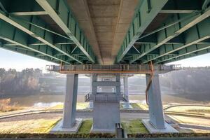 steel frame and concrete construction huge car bridge across the wide river photo