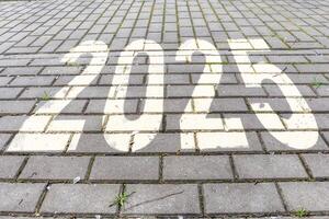 numbers 2025 on paving slabs. concept of destination in future, freedom, work start, run, planning, challenge, target, new year photo