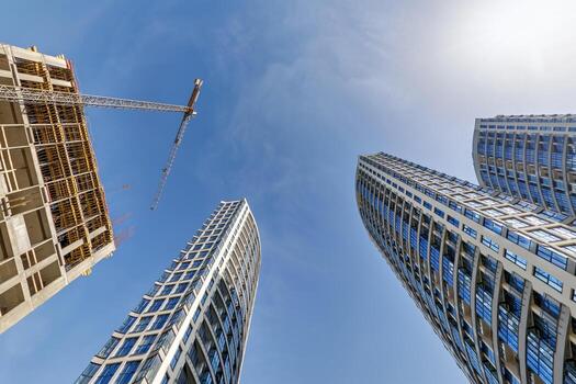 ver desde abajo dentro azul cielo con nubes de grande moderno rascacielos residencial complejo foto