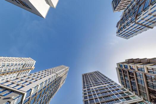 ver desde abajo dentro azul cielo con nubes de grande moderno rascacielos residencial complejo foto