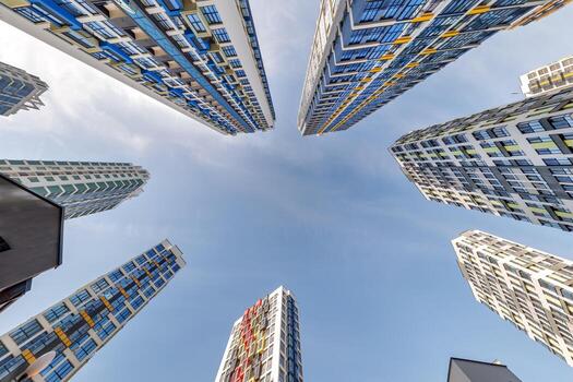 ver desde abajo dentro azul cielo con nubes de grande moderno rascacielos residencial complejo foto