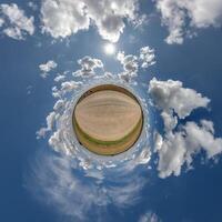 simple tiny planet without buildings in blue sky with beautiful clouds. Transformation of spherical panorama 360 degrees. Spherical abstract aerial view. Curvature of space. photo