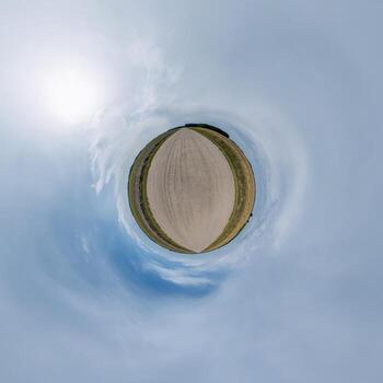 simple tiny planet without buildings in blue sky with beautiful clouds. Transformation of spherical panorama 360 degrees. Spherical abstract aerial view. Curvature of space. photo