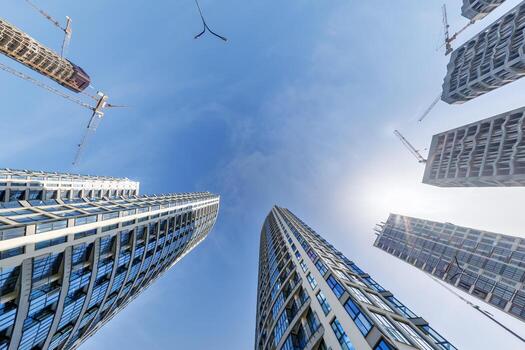 ver desde abajo dentro azul cielo con nubes de grande moderno rascacielos residencial complejo foto