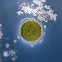 simple tiny planet without buildings in blue sky with beautiful clouds. Transformation of spherical panorama 360 degrees. Spherical abstract aerial view. Curvature of space. photo