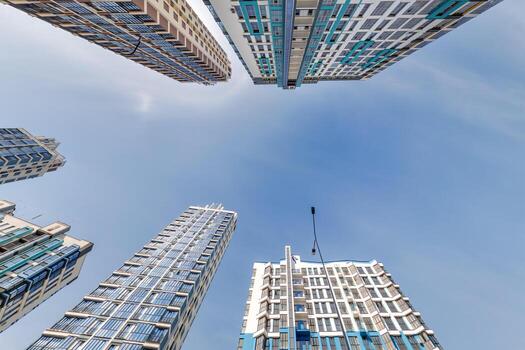 ver desde abajo dentro azul cielo con nubes de grande moderno rascacielos residencial complejo foto