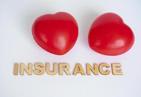 Heart shapes with insurance text on white background. Life insurance concept photo