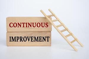 Continuous improvement text on wooden blocks. Business improvement concept photo