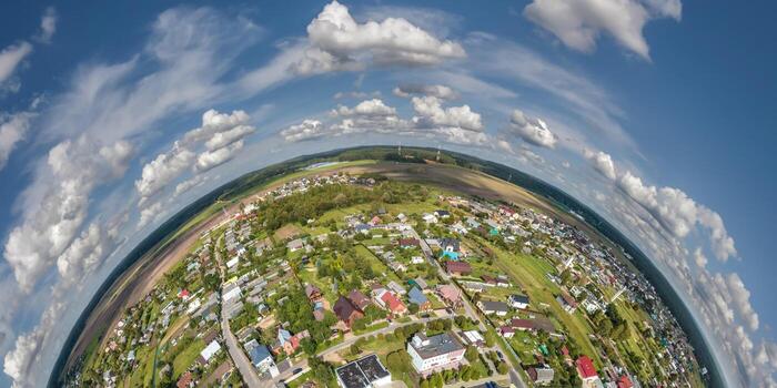 Aerial view from high altitude tiny planet in sky with clouds overlooking old town, urban development, buildings and crossroads. Transformation of spherical 360 panorama in abstract aerial view. photo