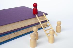 Ladder of success concept with books and doll figure climbing books with ladder photo