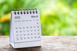 March 2025 white table calendar with customizable space for text. Calendar concept and copy space. photo