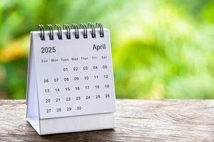 April 2025 white table calendar with customizable space for text. Calendar concept and copy space. photo