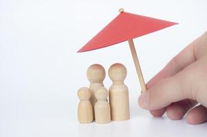 Family wooden dolls covered with toy umbrella with customizable space for text. Copy space concept photo