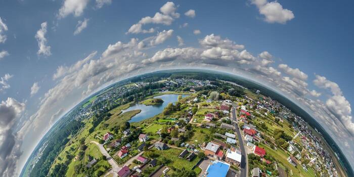 Aerial view from high altitude tiny planet in sky with clouds overlooking old town, urban development, buildings and crossroads. Transformation of spherical 360 panorama in abstract aerial view. photo