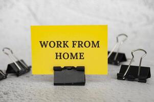 Work from home text on standing yellow paper. Working culture concept photo