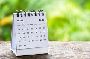 June 2025 white table calendar with customizable space for text. Calendar concept and copy space. photo