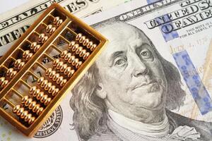 Gold abacus on banknote money, finance trading investment business currency concept. photo