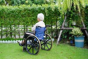 Asian elderly woman disability patient exercise on wheelchair with doctor in park, medical concept. photo