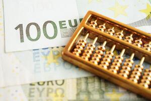 Gold abacus on banknote money, finance trading investment business currency concept. photo