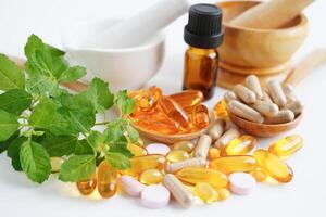 medicina alternativa cápsula orgánica a base de hierbas con vitamina e omega 3 aceite de pescado, mineral, medicamento con hojas de hierbas suplementos naturales para una vida sana y buena. foto