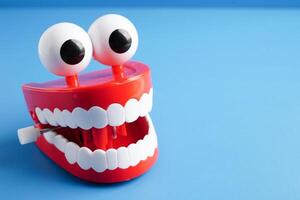 Funny red teeth with eye toy denture model for dental health care. photo