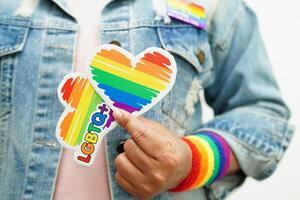 mujer asiática con bandera del arco iris, derechos de símbolos lgbt e igualdad de género, mes del orgullo lgbt en junio. foto