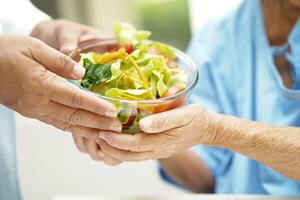 Asian Nutritionist holding healthy food for patient in hospital, nutrition and vitamin. photo