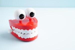 Funny red teeth with eye toy denture model for dental health care. photo