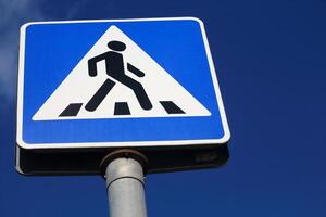 Sign pedestrian crossing on blue sky background bottom up view photo