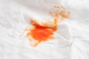 Dirty spicy sauce stain on cloth to wash with washing powder, cleaning housework concept. photo