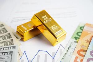 Gold bars with US dollar and Euro banknote money, finance trading investment business currency concept. photo