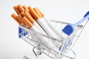 Cigarette in shopping cart, cost, trading, marketing and production, No smoking concept. photo