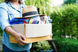 Volunteer collect cloth and hat in cardboard box to donate. photo