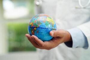 Asian man doctor holding globe, Elements of this image furnished by NASA. photo