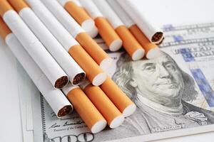 Cigarette on US dollar banknotes, cost, trading, marketing and production, No smoking concept. photo